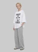 Pray First white T-shirt by Kingdom Mind Apparel featuring a simple prayer-themed design on the front.