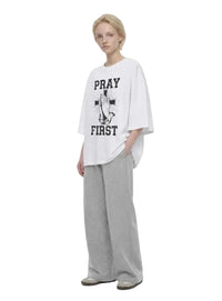 Pray First white T-shirt by Kingdom Mind Apparel featuring a simple prayer-themed design on the front.